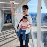 공항 터미널에서 웃으며 사진 찍는 가족 모습.